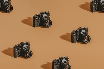 SLR cameras, black brown wooden table
